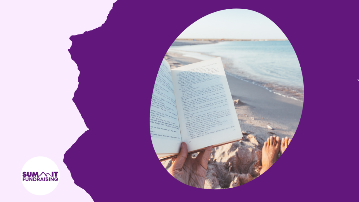 The image depicts a person reading a book while sitting on a sandy beach. The person’s feet are visible, relaxed, and resting on the sand, with the ocean and shoreline stretching into the distance. The scene is framed by a purple background with a white logo at the bottom left corner that reads "SUMMIT Fundraising."
